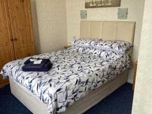 a bed with a blue and white comforter on it at Cavendish House in Weymouth