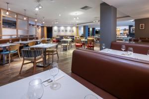 um restaurante com mesas e cadeiras e um bar em Holiday Inn Reading South M4 Jct 11, an IHG Hotel em Reading