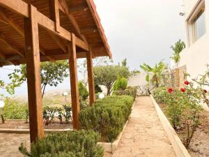 een tuin met een loopbrug naast een gebouw bij Tranquila Vista - Villa au cœur de la nature in Tanger