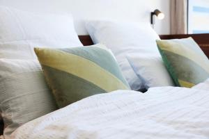 Una cama con almohadas blancas. en TIN INN l Hückelhoven einfach gut - Das Hotel aus hochwertig ausgebauten Überseecontainern en Hückelhoven