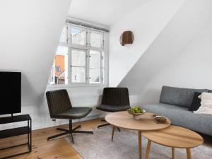 a living room with a couch and two chairs and a table at Sanders Saint - Loft One-Bedroom Apartment By the Charming Canals in Copenhagen