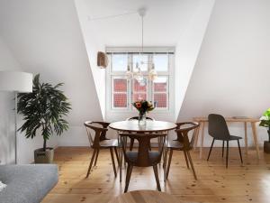 comedor con mesa, sillas y ventana en Sanders Saint - Loft One-Bedroom Apartment By the Charming Canals, en Copenhague
