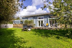 a blue house with a yard in front of it at Swanpool, Great Field Lodges, Braunton in Braunton