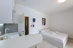 a hospital room with two beds and a sink at Seagull Pool Apartments & Studios in Novalja