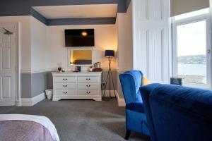 um quarto com uma cama, uma cómoda e uma janela em MacKays em Oban