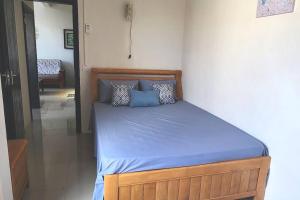 a bed with blue sheets and pillows in a bedroom at Number 8, 2nd Floor, Pebble Bay Apartments in Grand Baie