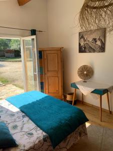 a bedroom with a bed and a table and a window at La chambre haute et son spa in Nîmes