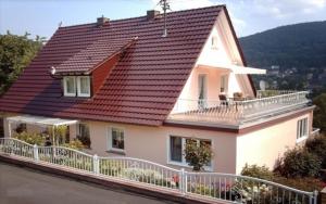 a white house with a red roof and a balcony at Ferienwohnung Lioba Kunst in Amorbach