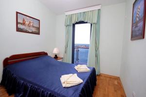 a bedroom with a blue bed and a window at Plava Vila Beach Apartments Sveti Stefan in Sveti Stefan