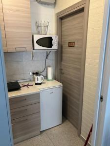 eine Küche mit einer Theke mit einer Mikrowelle und einer Tür in der Unterkunft La Rosa di Verona in Verona
