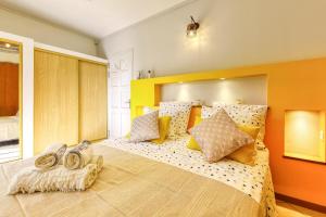 a bedroom with a large bed with colorful pillows at Kaz Voyageur in Saint-Paul