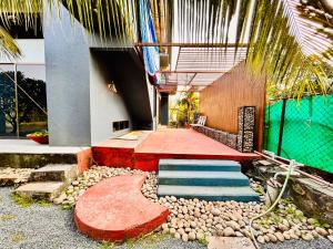 ein Gebäude mit einer Treppe und einer Palme davor in der Unterkunft NzoStay Casa Cobble Luxury Villa Alibaug in Alibag