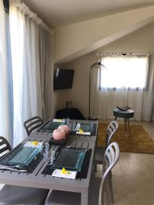 a dining room table with chairs and a table with food on it at Appartement Artistique de Boucan Canot in Saint-Paul