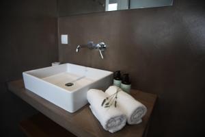 un bagno con lavandino e asciugamani su un bancone di Athens Market Apartments, Amazing Acropolis View ad Atene Altre 41 foto