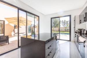 a kitchen with large windows and a large counter top at Luxury stylish 3suits villa in Marrakech