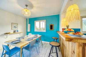 a dining room with blue walls and a table with blue chairs at Kaz Trou d Eau in Saint-Paul