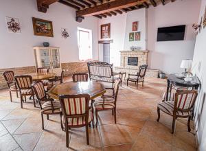 Fermo della Guazzona في بوسيتو: غرفة بها طاولات وكراسي ومدفأة