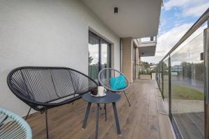 a patio with two chairs and a table on a balcony at Apartment Five Seas with Parking & Swimming Pool by Renters in Sianozety