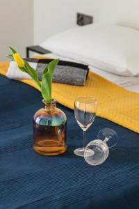 a vase with a plant in it next to a wine glass at Apartment Five Seas with Parking & Swimming Pool by Renters in Sianozety