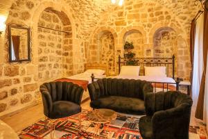 1 Schlafzimmer mit einem Bett, 2 Stühlen und einem Tisch in der Unterkunft Nostalji in Mardin