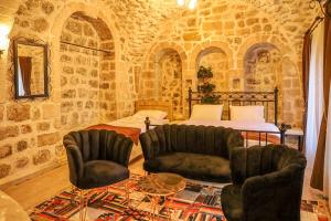 a bedroom with a bed and two chairs and a table at Nostalji in Mardin