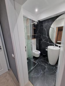 La salle de bains est pourvue d'un lavabo, d'une baignoire et de toilettes. dans l'établissement Hotel Muntele Mic, à Borlova