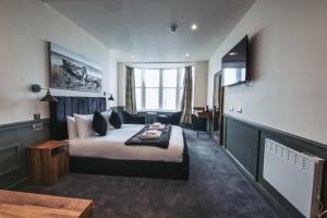 a hotel room with a bed and a desk at The Royal Bar & Shaker in Morecambe