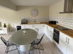 オスウェストリーにあるTownhouse Apartmentのキッチン(テーブル、椅子、壁掛け時計付)