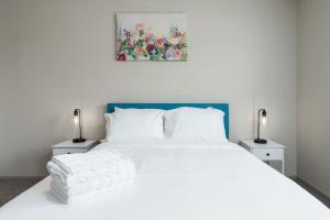 ein Schlafzimmer mit einem weißen Bett und zwei Nachttischen in der Unterkunft Affordable 2-Bed Fishers in Fishers