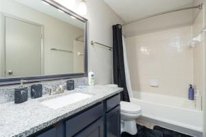 La salle de bains est pourvue d'un lavabo, de toilettes et d'un miroir. dans l'établissement Affordable 2-Bed Fishers, à Fishers