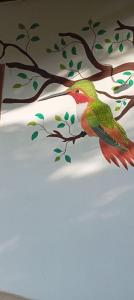 a painting of a bird perched on a tree branch at Sierra Kay Hostel in Guachaca