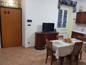 eine Küche mit einem Tisch mit Stühlen und einem TV in der Unterkunft Vecchia Dimora in Marino