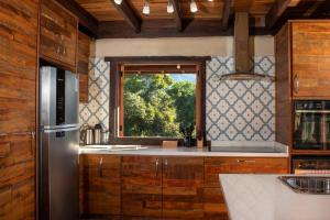 a kitchen with a window and a refrigerator at Eco Lodge de Construção Natural com Vista Panorâmica in Nova Friburgo
