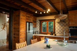 a kitchen with a refrigerator and a table with chairs at Eco Lodge de Construção Natural com Vista Panorâmica in Nova Friburgo +37 photos