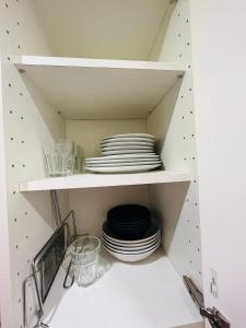 a cupboard with plates and dishes in it at Stationnement Gratuit, 3mn du Métro, Parfait pour Télétravailler in Maisons-Alfort