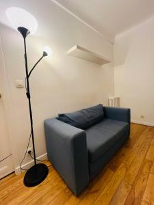 a blue couch in a living room with a lamp at Stationnement Gratuit, 3mn du Métro, Parfait pour Télétravailler in Maisons-Alfort