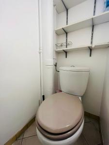 um WC branco numa casa de banho com prateleiras em Stationnement Gratuit, 3mn du Métro, Parfait pour Télétravailler em Maisons-Alfort