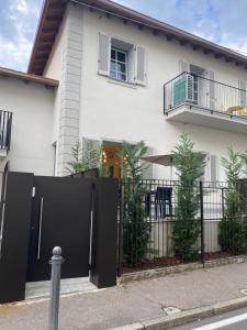 a white house with a black gate and fence at La casa di Giò: piccolo gioiello in centro Como in Como