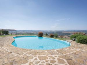 a swimming pool with a stone walkway around it at La Casa Di Bice in Asciano