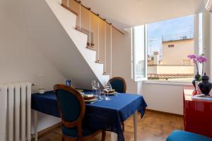 une salle à manger avec une table bleue, des chaises et une fenêtre dans l'établissement Vespucci Suite Home, à Florence