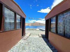 a building with windows and a view of the water at Native Retreat Cottage , Pangong ladakh UT in Meruk