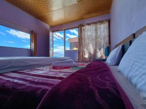 a bedroom with a large bed with a large window at Native Retreat Cottage , Pangong ladakh UT in Meruk