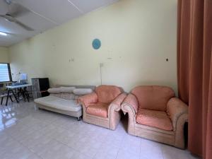 sala de estar con 2 sillas y sofá en Permai’s Stay, en Sibu