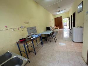 eine Küche mit einem Tisch und Stühlen im Zimmer in der Unterkunft Permai’s Stay in Sibu