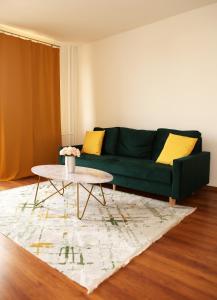 sala de estar con sofá verde y mesa de centro en New colorful apartment with big balcony, en Koliba