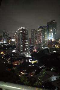 a city lit up at night with tall buildings at Somerset Condominium Tower 1 in Manila
