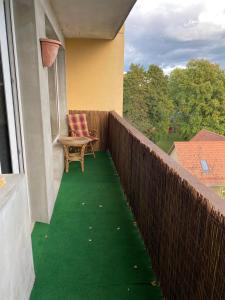 einen Balkon mit einem Stuhl und grünem Boden in der Unterkunft Vanalinna Apartment in Võru