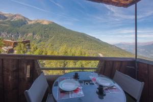 a table on a balcony with a view of a mountain at Le Sunny Snow - Jolie vue montagne in Les Orres