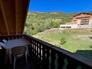 a balcony with a table and a view of a building at T2 mezzanine à Pra-Loup 1500, proche navette et vue montagnes - FR-1-165A-59 in Uvernet-Fours