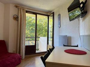 uma sala de estar com uma mesa e uma grande janela em Appartement Pra-Loup, 2 pièces, 4 personnes - FR-1-165A-82 em Uvernet